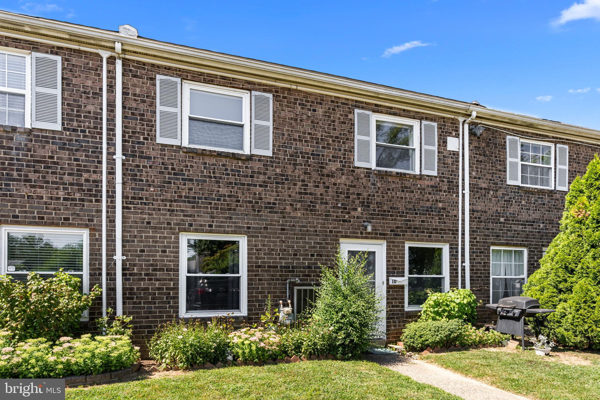 Charming brick facade with lush greenery.