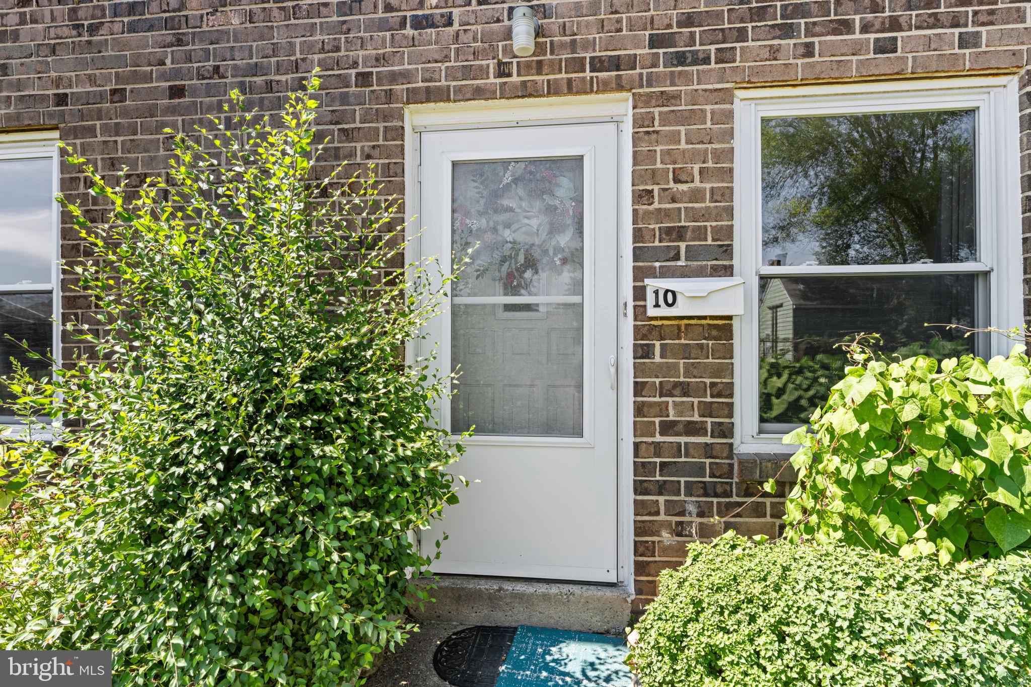 Charming entrance with lush greenery.