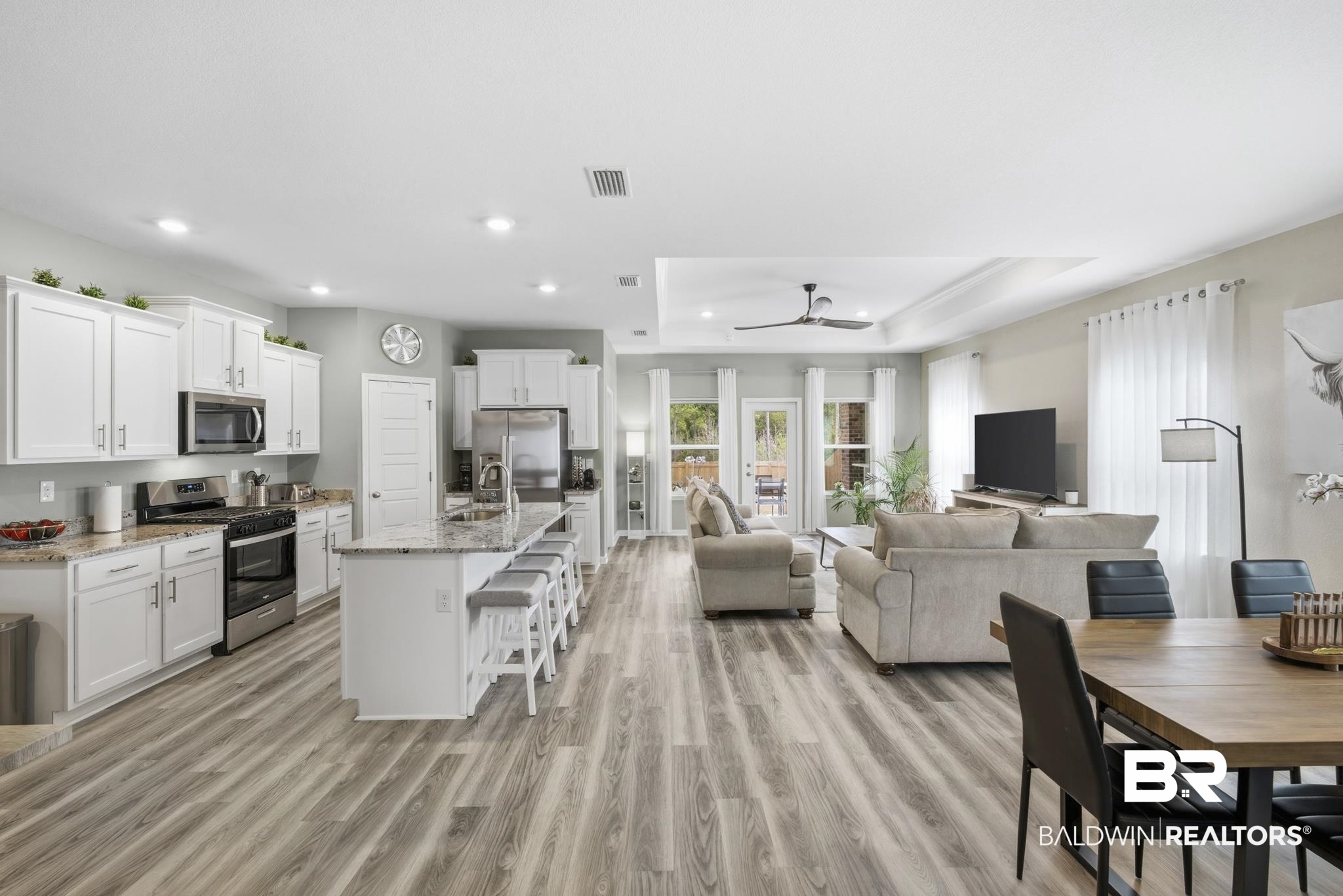 13887 Antler Hl Road Daphne, AL 36527 - Photo 49 of 50 Kitchen with a breakfast bar area, white cabinets, stainless steel appliances, open floor plan, and light stone countertops