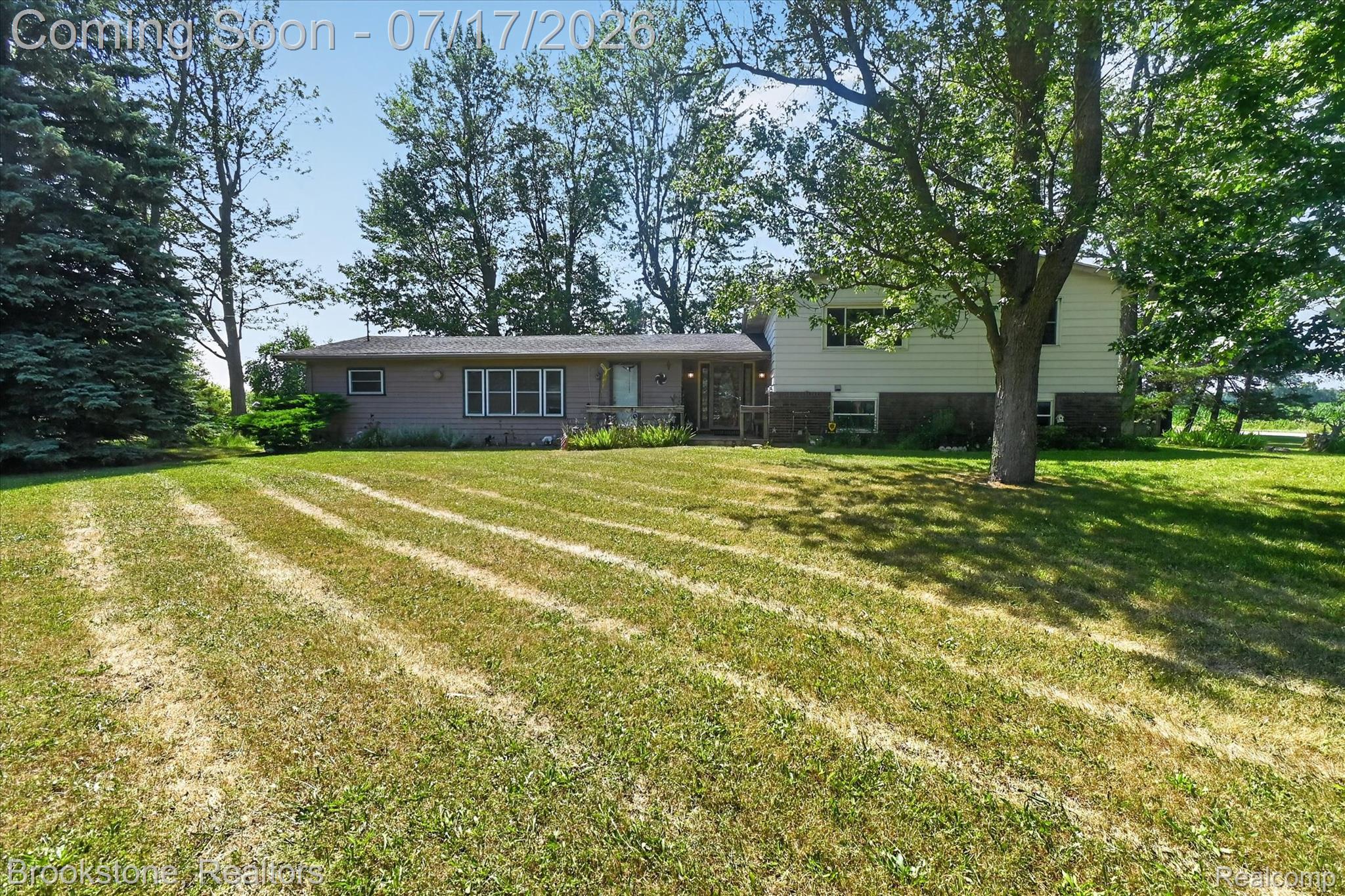 22025 Lakefield Road Merrill, MI 48637 - Photo 3 of 47 Exterior featuring two distinct architectural sections, mature trees, and a spacious lawn