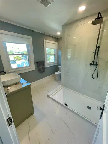 a bathroom with a tub a mirror and a shower