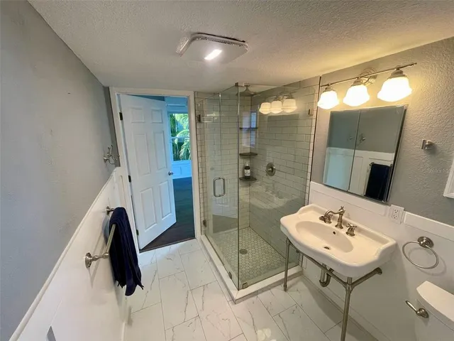 a bathroom with a sink mirror and shower