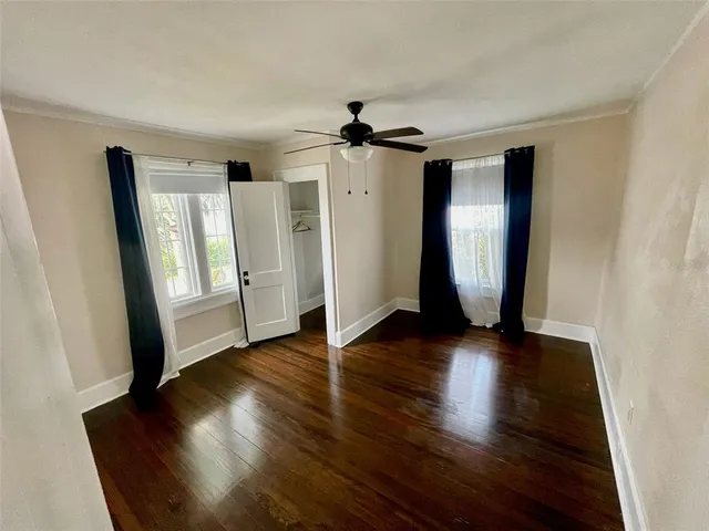 a view of a hallway with wooden floor and stairs