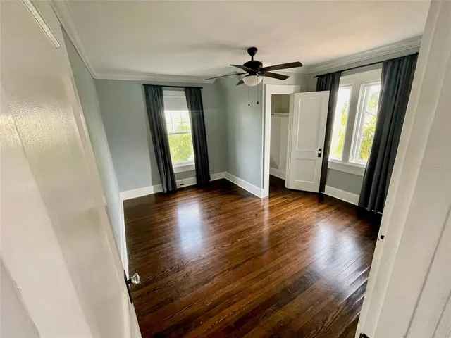 a view of a hallway with wooden floor and staircase