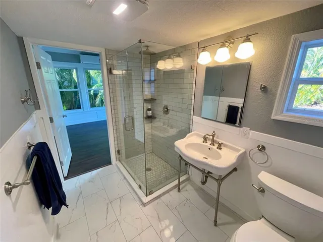 a bathroom with a tub a mirror and a shower