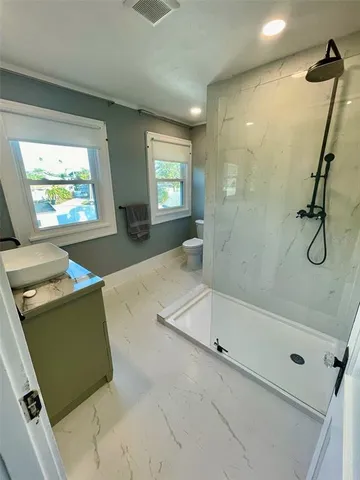 a bathroom with a sink a toilet a mirror and window