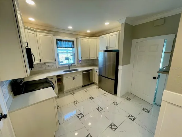 a kitchen with stainless steel appliances a refrigerator sink and wooden cabinets