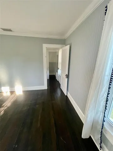 an empty room with wooden floor and a fireplace