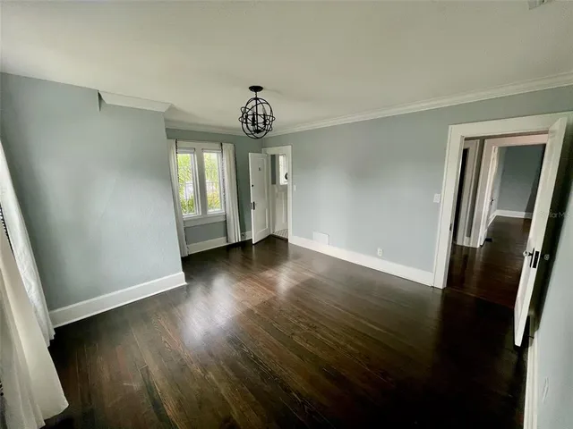 an empty room with wooden floor and window