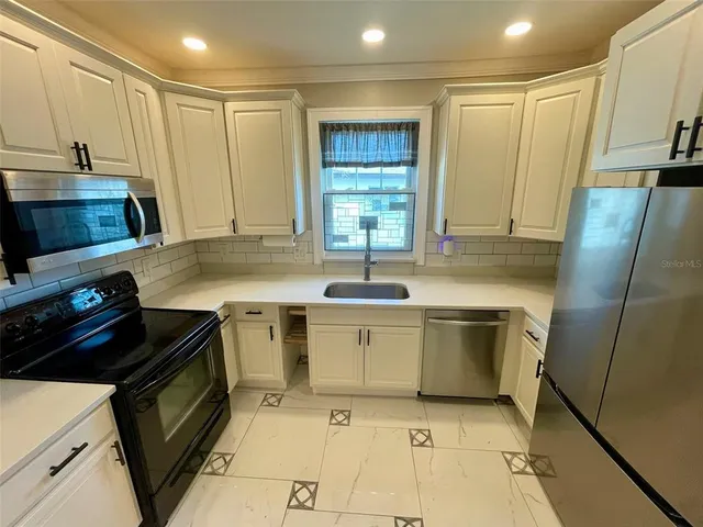 a kitchen with a sink stove and cabinets