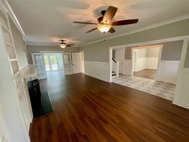 a view of a livingroom with a ceiling fan and wooden floor