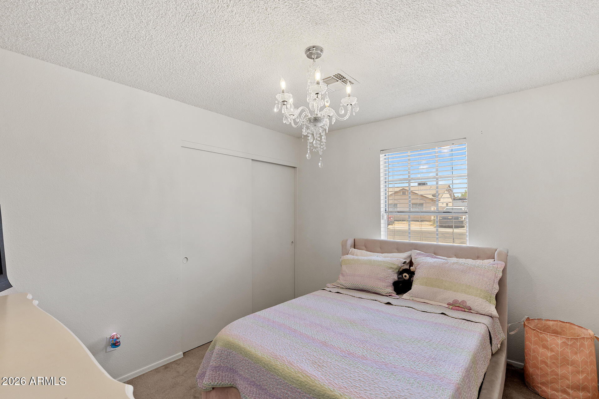 9002 West Coronado Road Phoenix, AZ 85037 - Photo 40 of 54 a bedroom with a bed and a chandelier