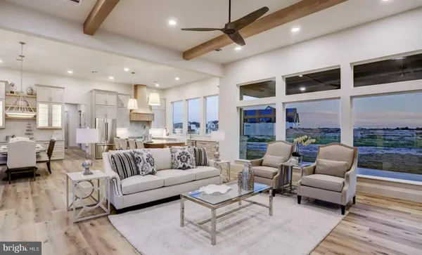 a living room with furniture kitchen view and a large window