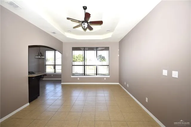 en empty room with windows and chandelier