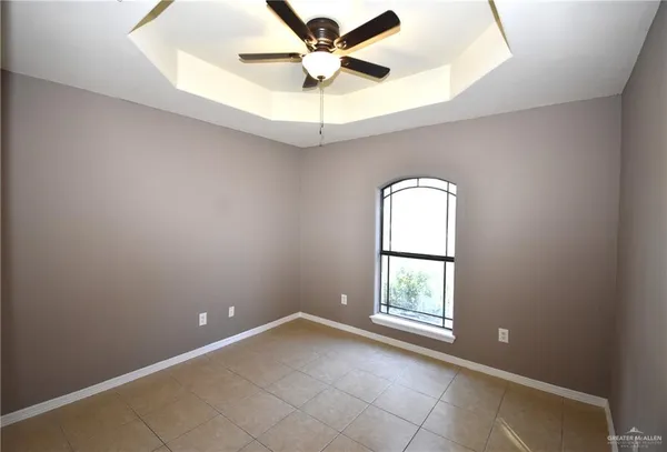 an empty room with a window and a chandelier fan