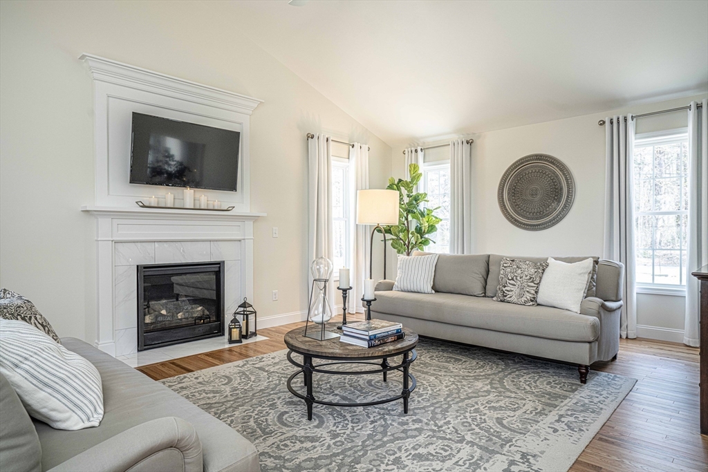 283 Plain Street Rehoboth, MA 02769 - Photo 10 of 13 a living room with a couch a rug and a fireplace
