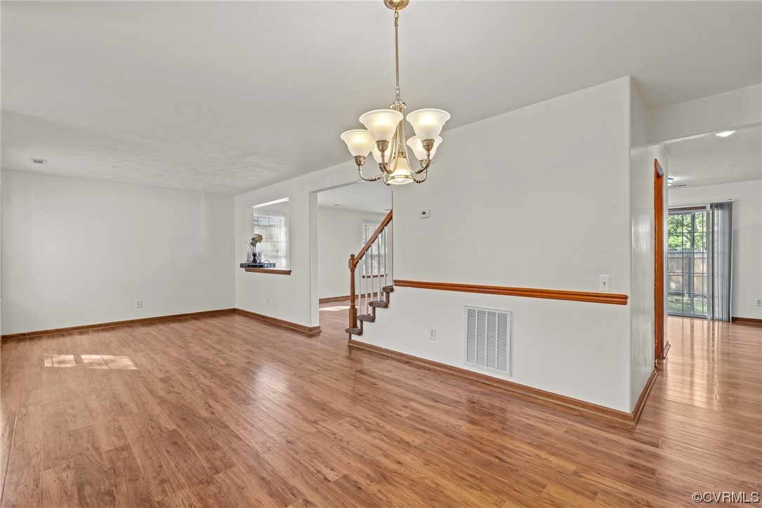 131 Stoney Ridge Avenue, Unit 52 Suffolk, VA 23435 - Photo 15 of 36 a view of an empty room with wooden floor and a chandelier