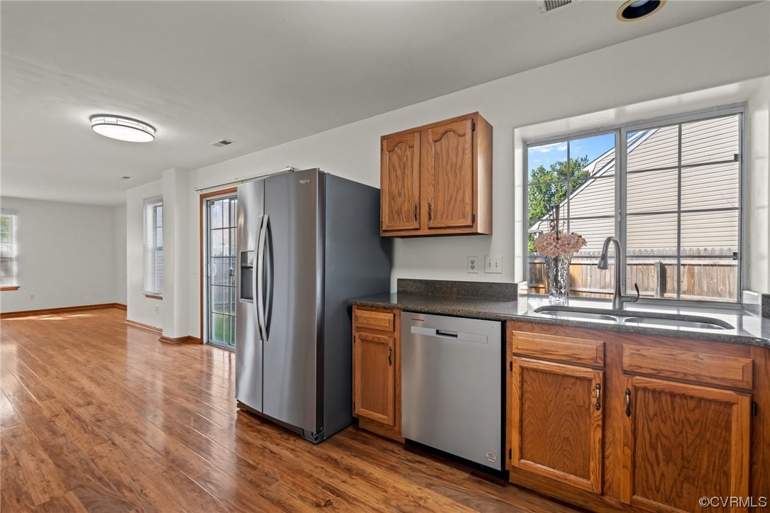131 Stoney Ridge Avenue, Unit 52 Suffolk, VA 23435 - Photo 9 of 36 a kitchen with stainless steel appliances granite countertop a refrigerator a sink dishwasher and wooden cabinets with wooden floor