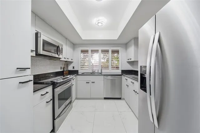 a kitchen with stainless steel appliances granite countertop a stove a refrigerator and a microwave