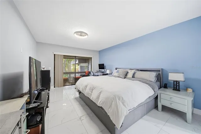 a large bedroom with a bed and a flat tv screen