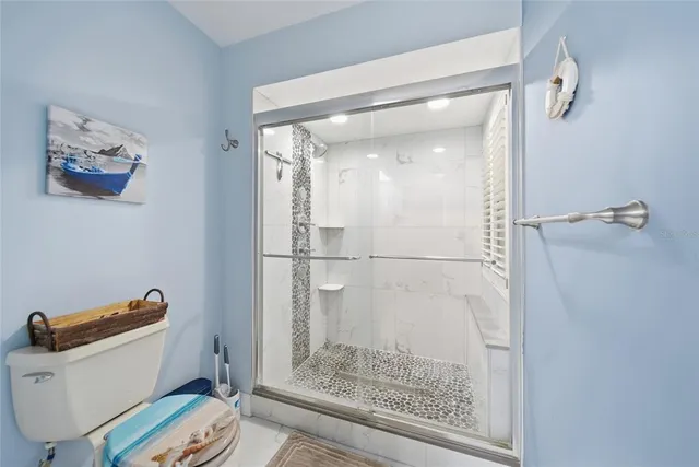 a bathroom with a toilet and a shower
