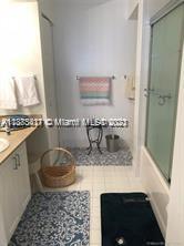 3606 South Ocean Boulevard, Unit 504 Highland Beach, FL 33487 - Photo 13 of 26 a bathroom with a granite countertop sink a mirror and shower