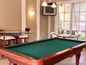 a room with pool table and windows