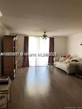 a hallway with a view of living room with furniture and windows