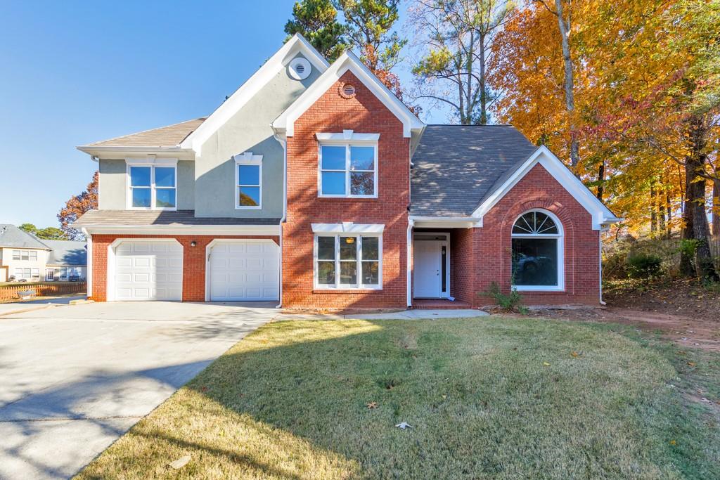 a front view of a house with a yard and garage