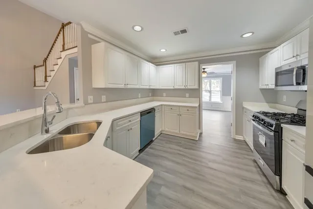 a kitchen with a sink a stove and cabinets