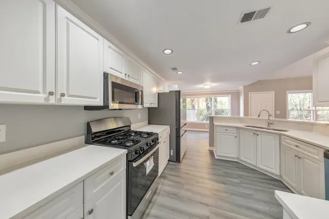 a kitchen with white cabinets and appliances