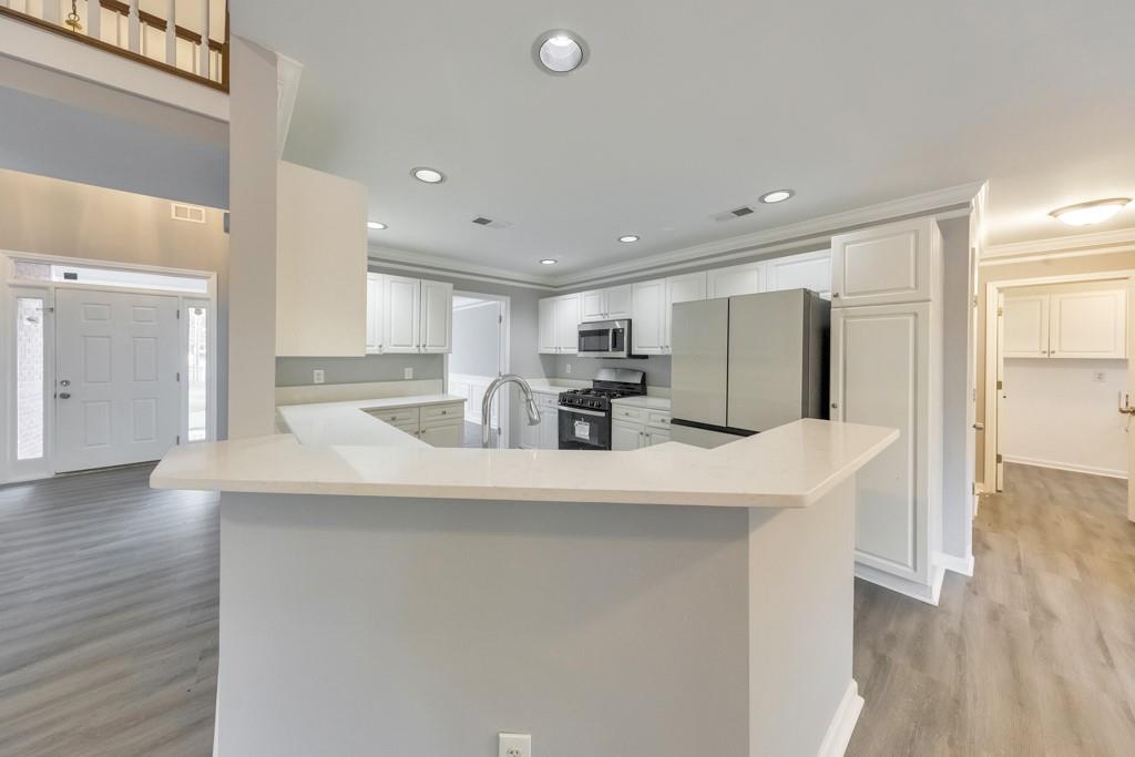 4804 Thicket Path Northwest Acworth, GA 30102 - Photo 21 of 48 a kitchen with stainless steel appliances granite countertop a refrigerator a sink dishwasher a stove and a refrigerator with wooden floor
