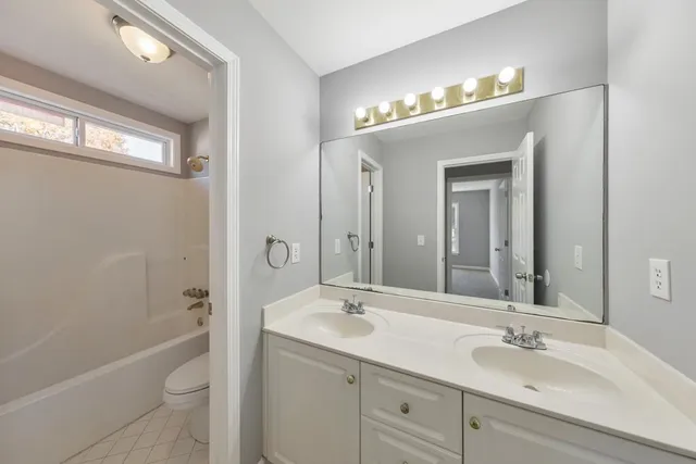 a bathroom with a sink a toilet a shower and a mirror