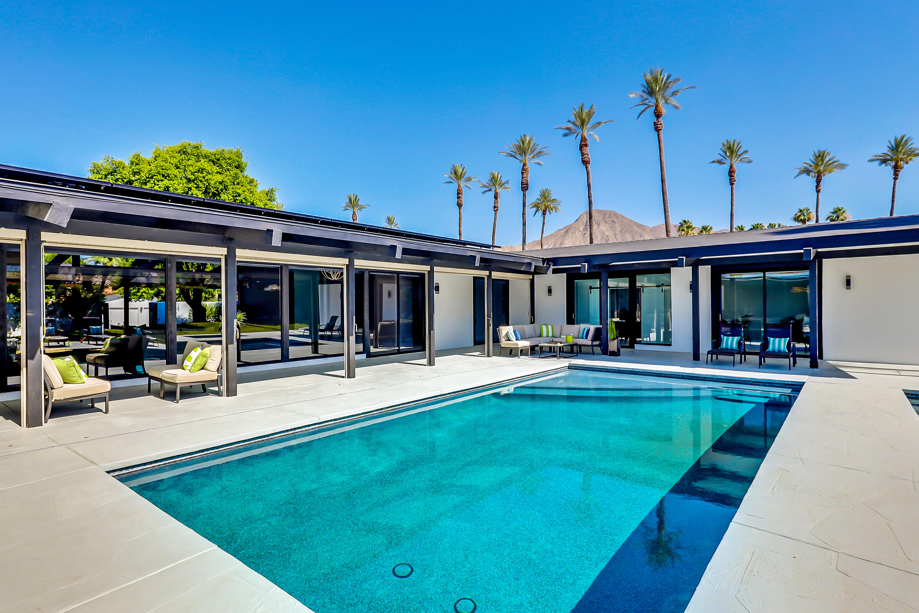 a view of a house with swimming pool and sitting area