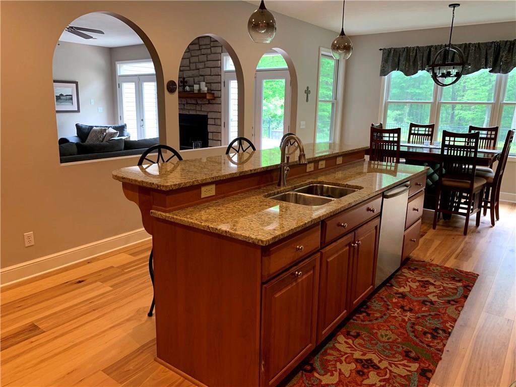 580 George Jr Road Grove City, PA 16127 - Photo 4 of 25 Stunning eat in kitchen with plenty of seating, archway to the living room and wall of windows and doors with pleasing views of the pool and wooded lot!
