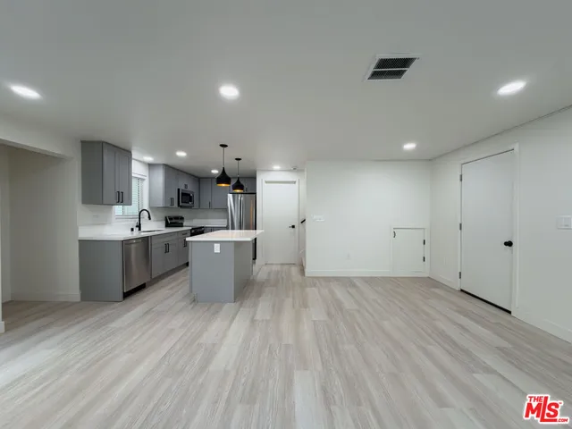 a large kitchen with a lot of counter space and a wooden floor