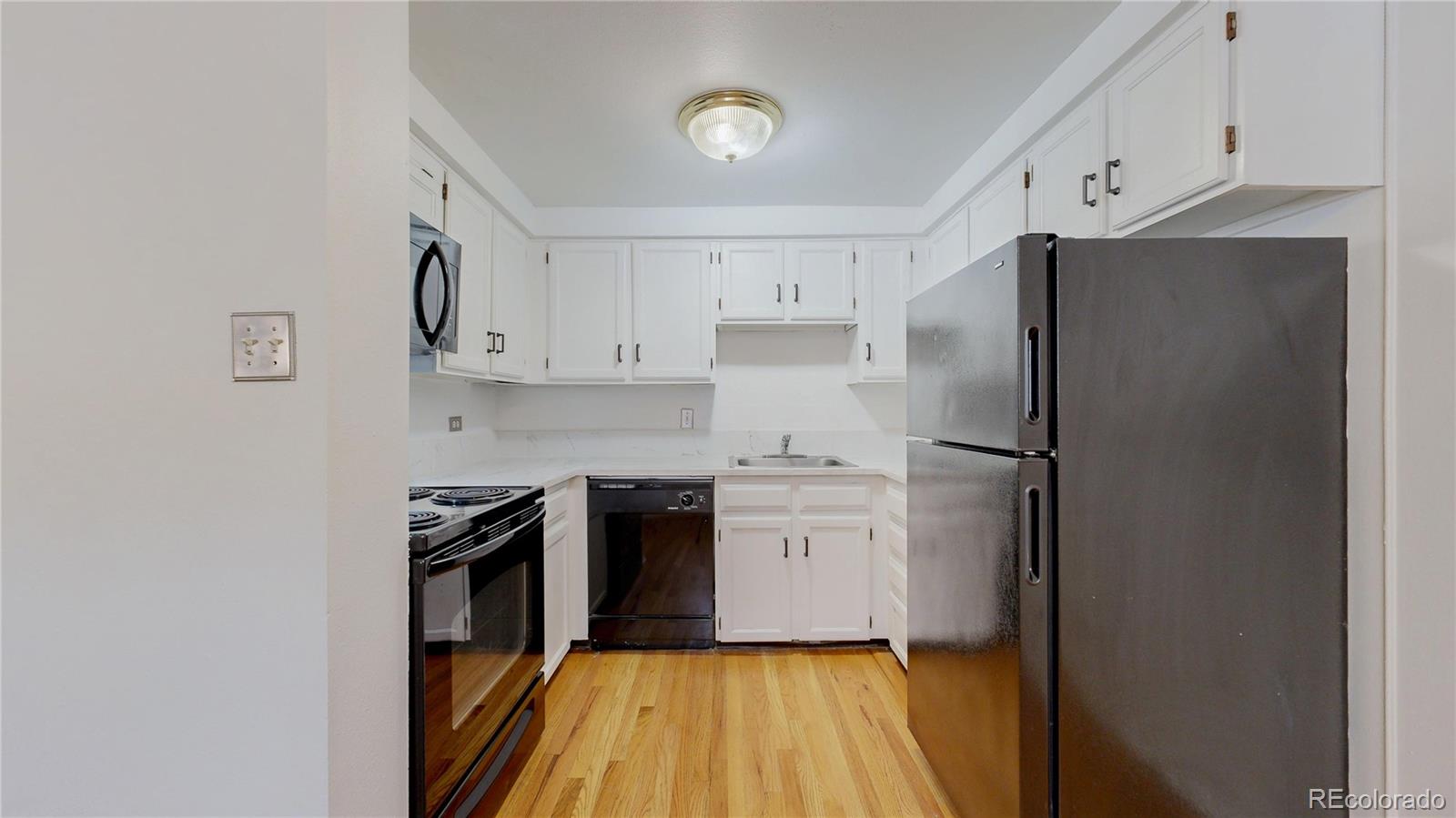 1350 Josephine Street, Unit 101A Denver, CO 80206 - Photo 11 of 36 a kitchen with stainless steel appliances a refrigerator sink and white cabinets