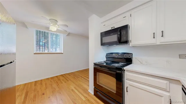 a kitchen with granite countertop cabinets stainless steel appliances and wooden floor