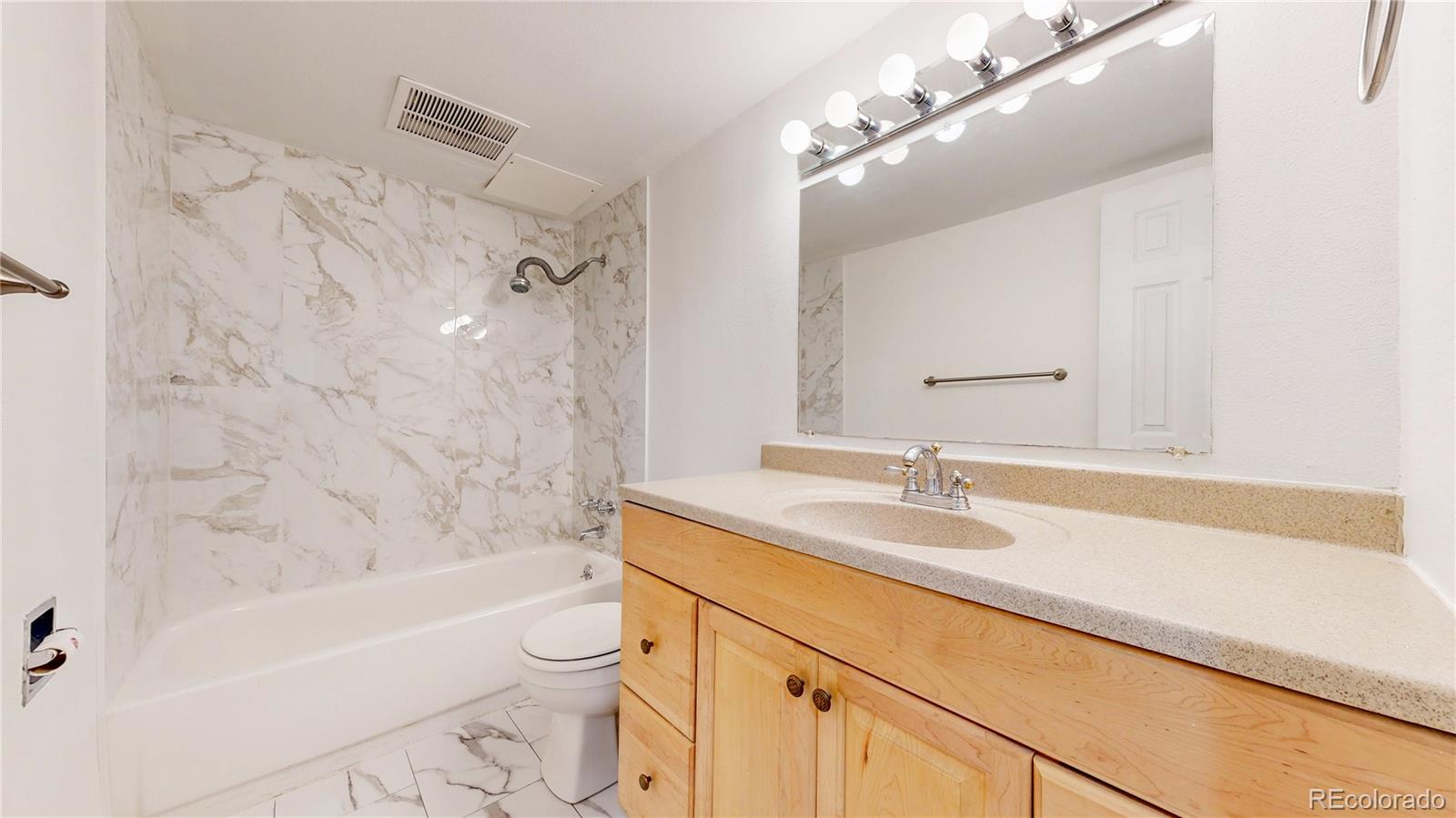 1350 Josephine Street, Unit 101A Denver, CO 80206 - Photo 19 of 36 a bathroom with a granite countertop sink a toilet and bathtub