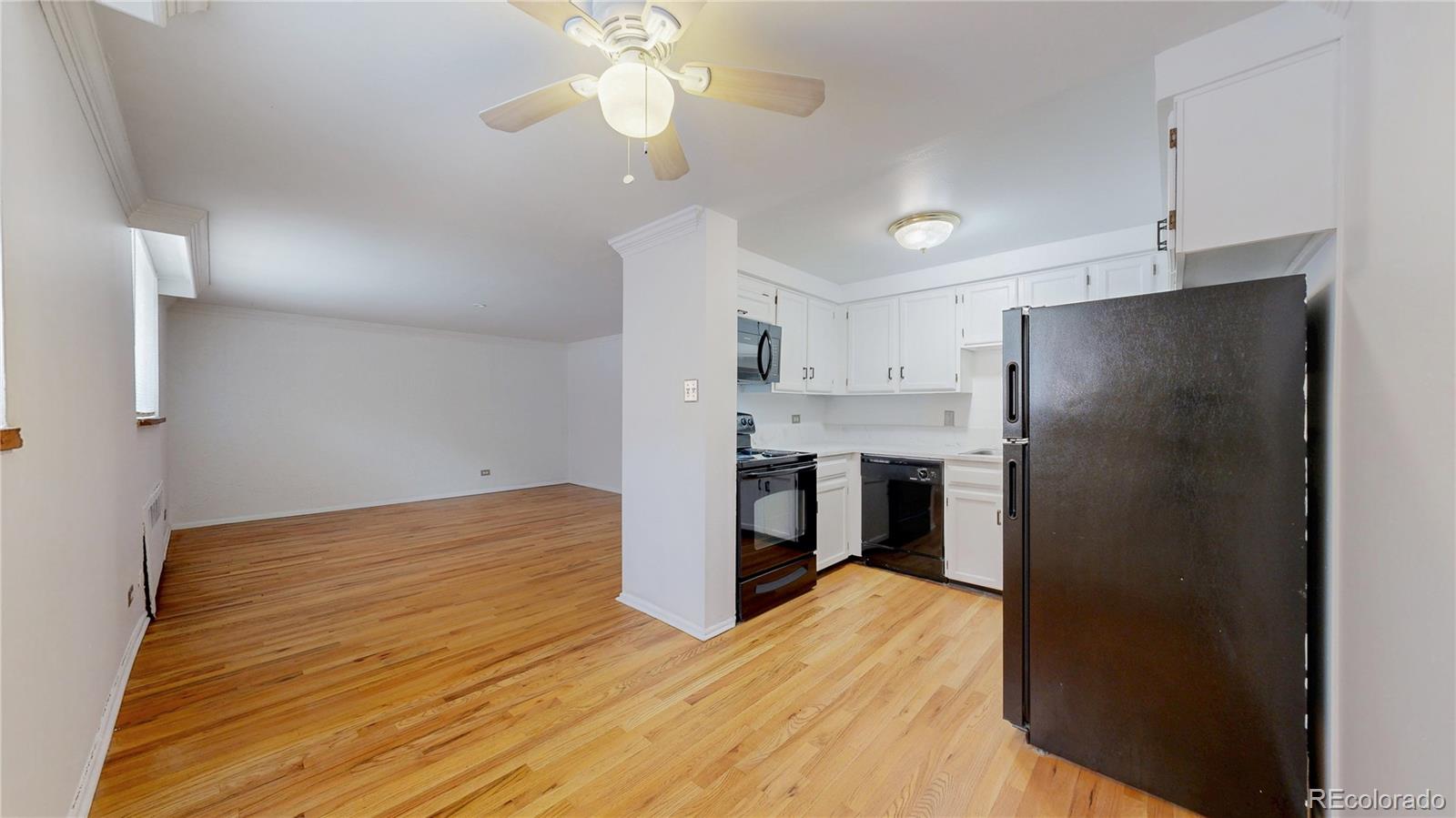 1350 Josephine Street, Unit 101A Denver, CO 80206 - Photo 10 of 36 a kitchen with stainless steel appliances a refrigerator and a chandelier
