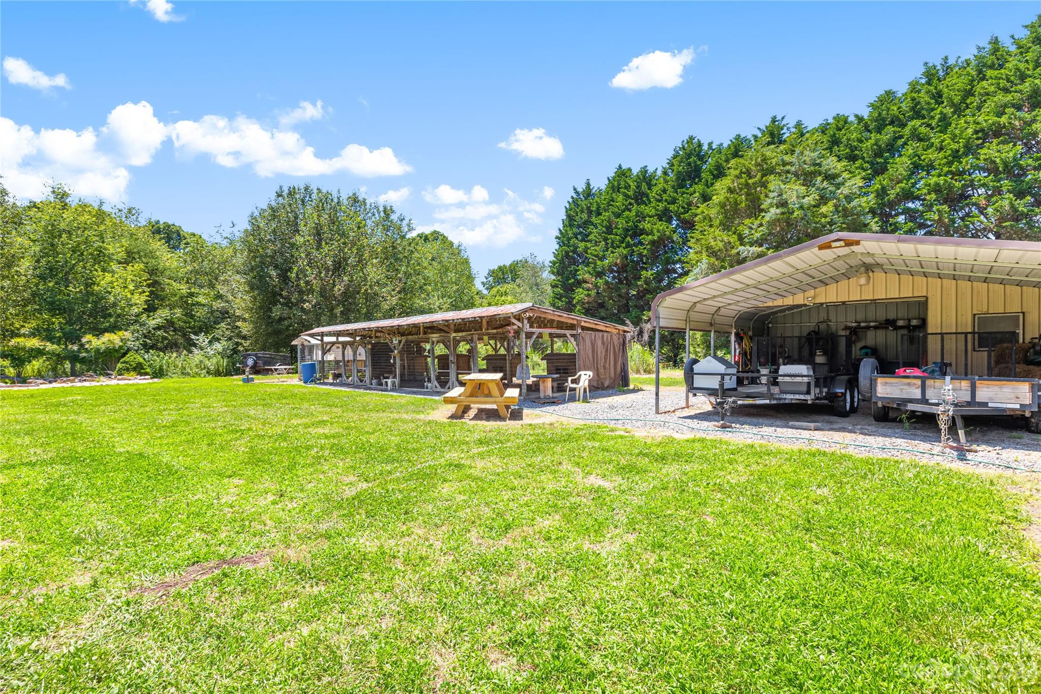 137 Brook Road Kings Mountain, NC 28086 - Photo 36 of 46 a view of a swimming pool with lawn chairs under an umbrella with large trees