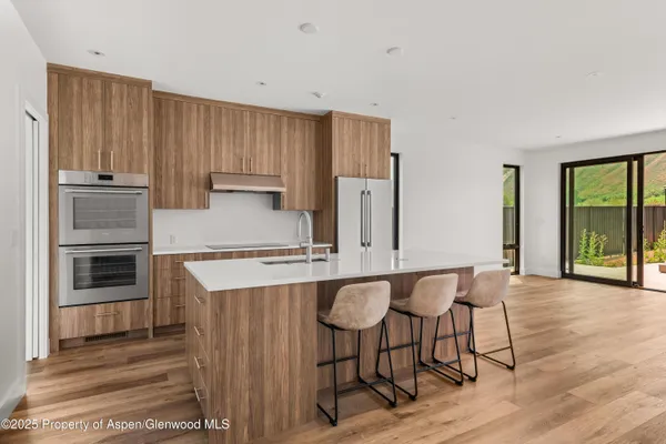 a kitchen with stainless steel appliances granite countertop a stove top oven a sink and white cabinets