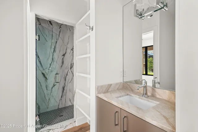 a bathroom with a granite countertop shower a sink and a mirror