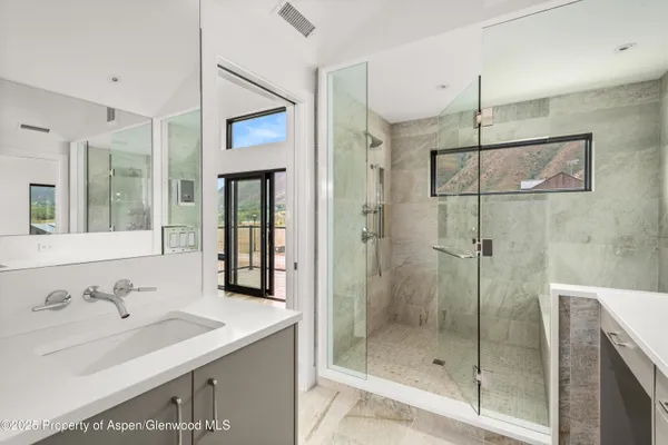a bathroom with a shower sink and mirror