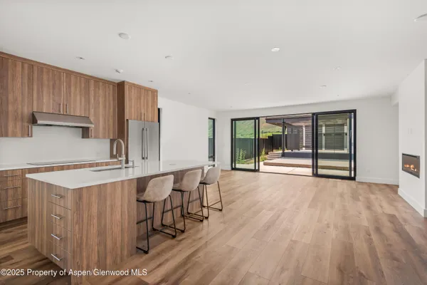 a kitchen with stainless steel appliances a table and chairs in it