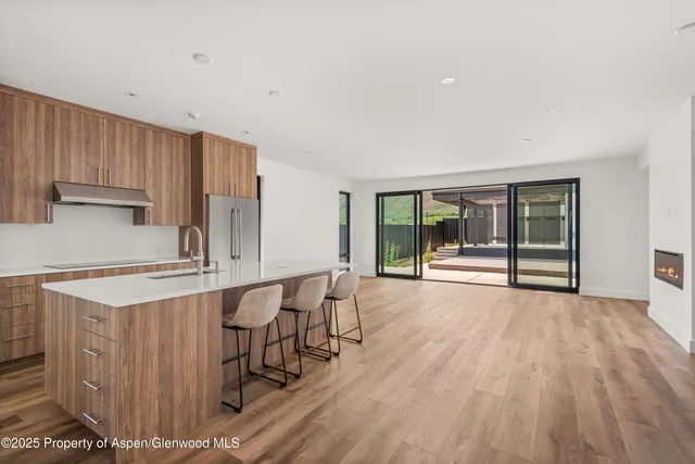 a kitchen with stainless steel appliances a table and chairs in it