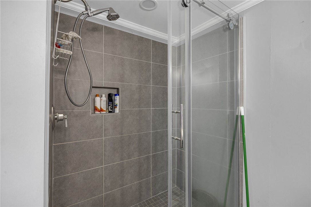 1549 Bethany Church Road Belton, SC 29627 - Photo 21 of 36 Modern shower with sleek gray tiling and convenient built-in shelving.