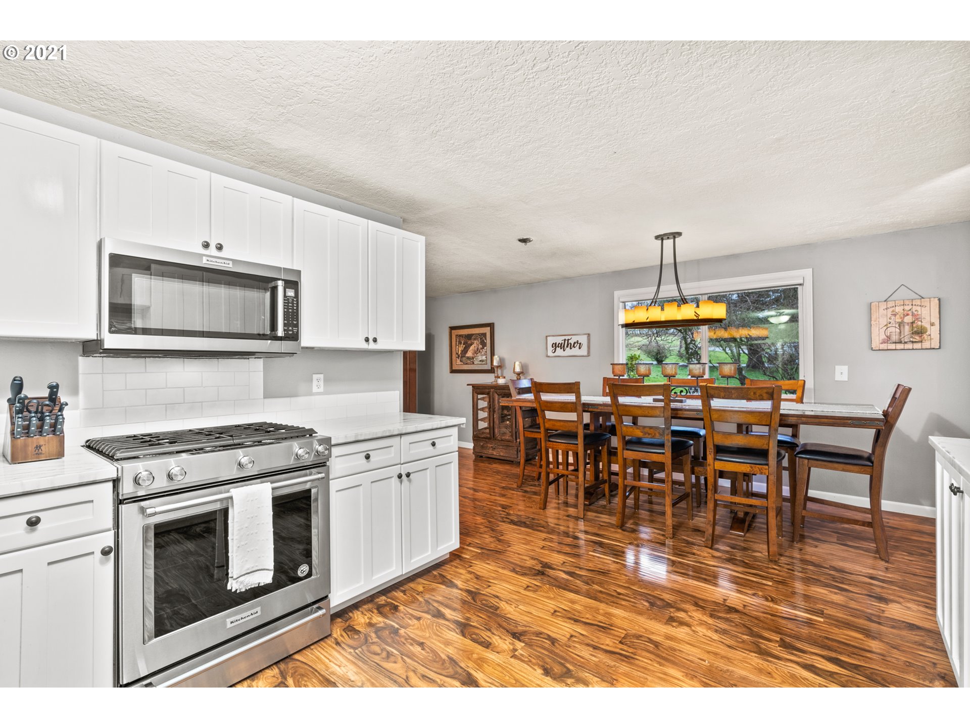 716 Northeast Evans Road Corbett, OR 97019 - Photo 6 of 32 a kitchen with stainless steel appliances granite countertop a stove a sink a dining table and chairs