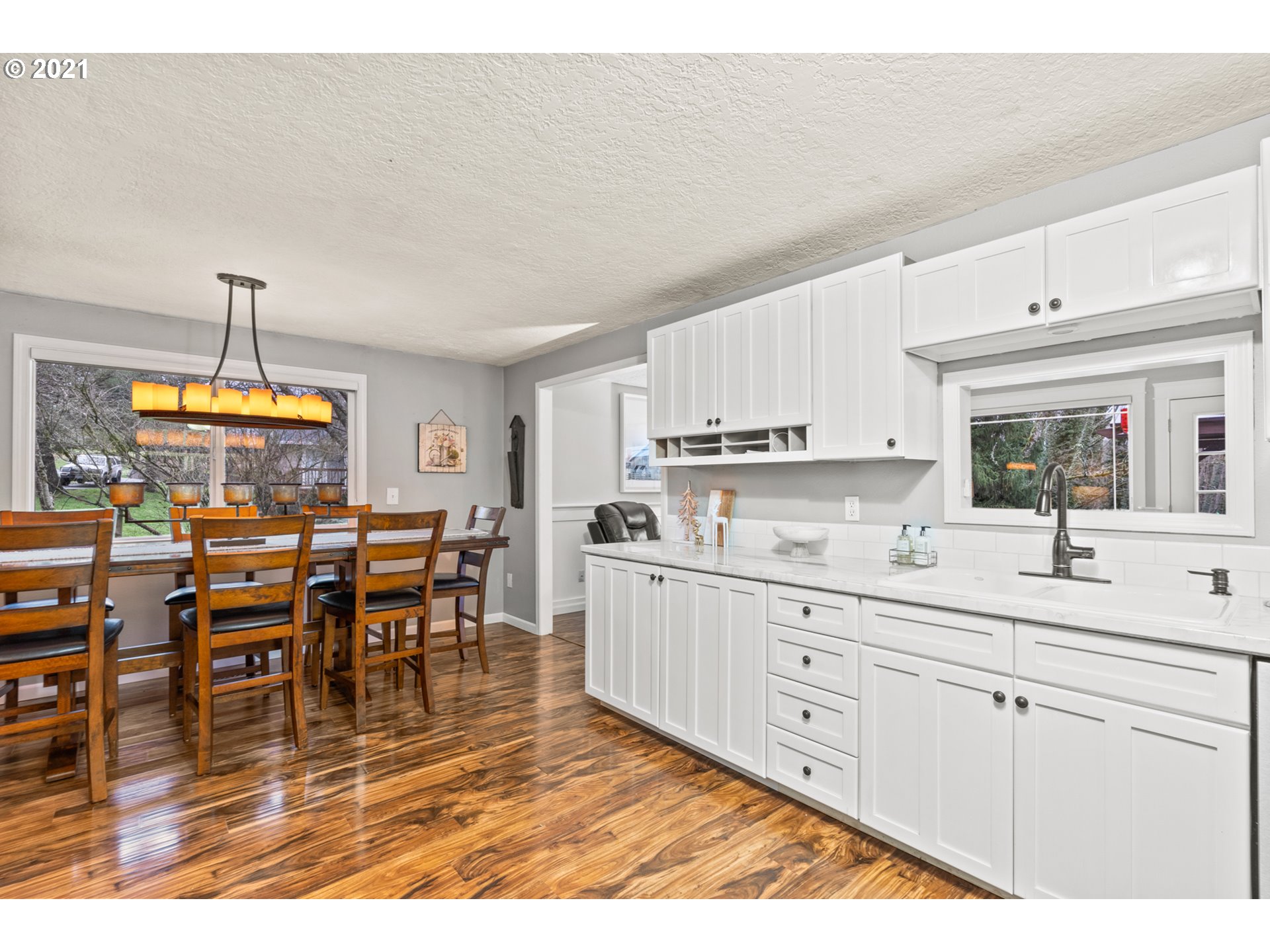 716 Northeast Evans Road Corbett, OR 97019 - Photo 7 of 32 a kitchen with stainless steel appliances kitchen island granite countertop a stove a sink a dining table and chairs with wooden floor