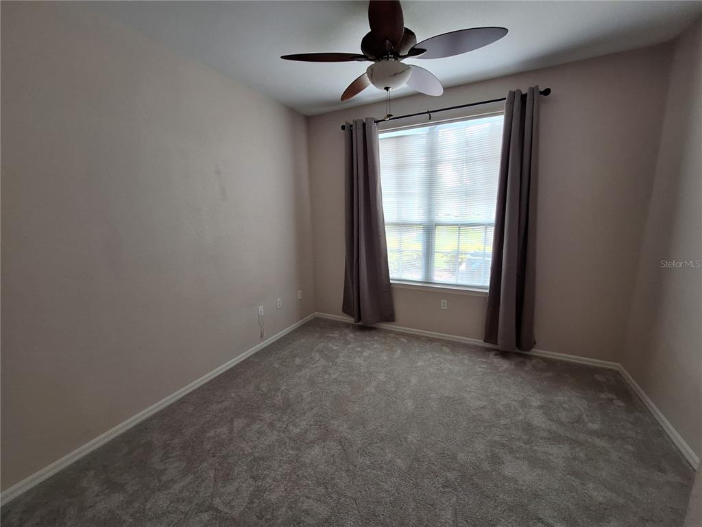 5550 Rosehill Road, Unit 103 Sarasota, FL 34233 - Photo 17 of 28 an empty room with windows and ceiling fan